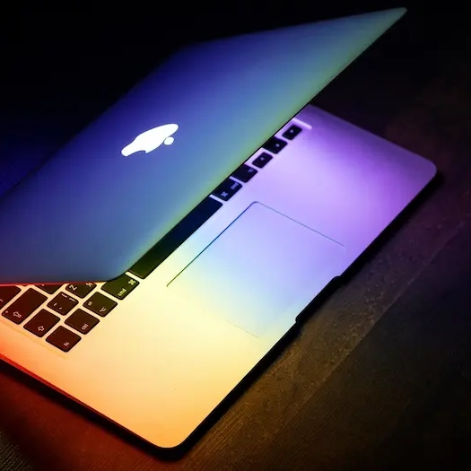 Macbook skærm og tastatur i et lyserødt rum